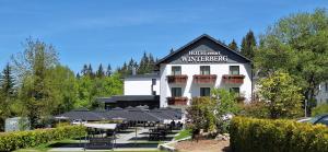 un hotel con molti tavoli e ombrelloni di Hotel Winterberg Resort a Winterberg