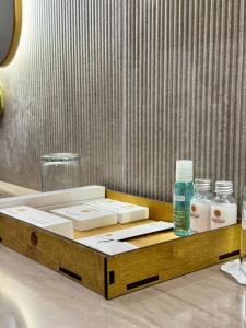 Una bandeja de madera con botellas de jabón y un lavabo. en Donatello Boutique Hotel, en Almaty 41 fotos más