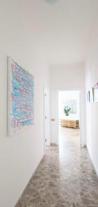 ein weißes Zimmer mit einem Gemälde an der Wand in der Unterkunft Angela's Apartment. Elegant two bedroom house in Irsina in Irsina