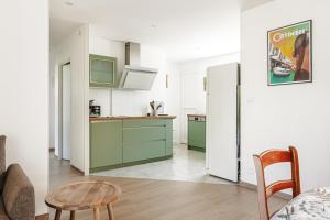 a kitchen with green cabinets and a white refrigerator at Grande maison entre plage et foret in Saint-Trojan-les-Bains
