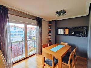 a dining room with a table and a large window at Modern duplex in downtown Cambados in Cambados