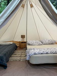 two beds in a canvas tent with a table at tenda bell in Gerez