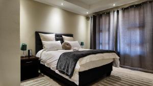 a bedroom with a large bed and a window at Ondjo Yetu in Benoni +27 photos