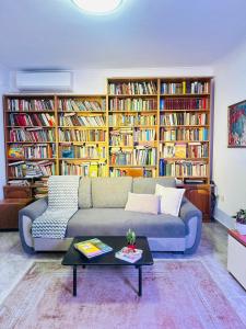 a living room with a couch and many books at Villa Center in Tirana