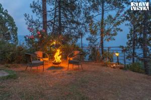 a group of chairs around a fire pit at night at StayVista at tatvam-Mountain views & EV Station in Lansdowne