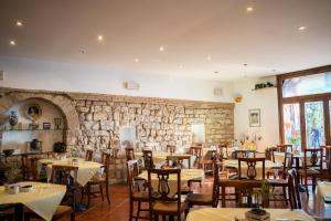 a restaurant with tables and chairs and a stone wall at Hotel Belvedere in Assisi