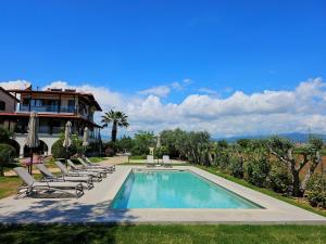 a swimming pool with lounge chairs and a house at Windmill Villa in Kalyves Poligirou