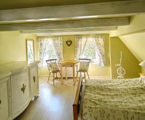 una camera da letto con due letti, un tavolo e delle sedie di Wsiowa Chata a Ścinawka Górna