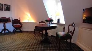 ein Raum mit einem Tisch und Stühlen und einem Fenster in der Unterkunft Herrenhaus Appartement 16 in Lüdersburg