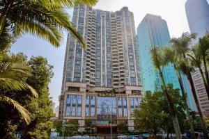 un grand bâtiment avec des palmiers devant dans l'établissement Liyuan Hotel, à Shenzhen
