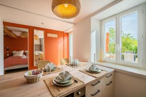 a room with orange walls and a table with plates on it at La Bastide - Terrasse - Jacuzzi in Carcassonne +10 photos
