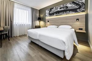 a hotel room with a large bed and a desk at Park Inn by Radisson Vilnius Airport Hotel & Conference Centre in Vilnius