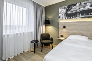 a hotel room with a bed and a chair at Park Inn by Radisson Vilnius Airport Hotel & Conference Centre in Vilnius +37 photos
