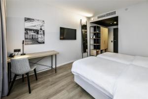 a bedroom with a bed and a desk and a television at Park Inn by Radisson Vilnius Airport Hotel & Conference Centre in Vilnius