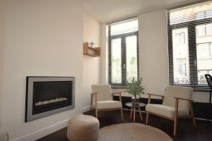 a living room with a fireplace and a table and chairs at Le Nid Marin in Ostend