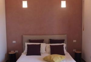 a bedroom with a white bed with two pillows at Castellabate House in Santa Maria di Castellabate