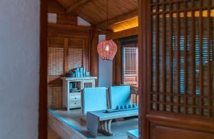 a room with two blue chairs and a table at Lijiang half yard hotel in Lijiang