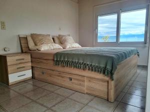 a bedroom with a large bed with a window at Elysian Blue in Petalidi