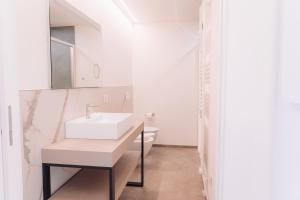 a white bathroom with a sink and a toilet at Holiday Apartments Campoverde in Salò +21 photos