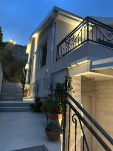 a white house with stairs and a balcony at Apartman Maja in Herceg-Novi