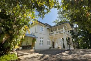 a large white house with a balcony on it at Mount Frenion Manor by Seven Angels Kandy in Murutalawa