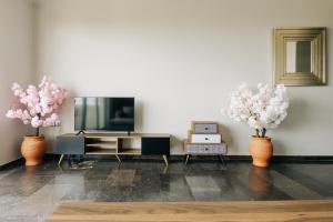 a living room with three vases with flowers in it at Panoramic Apartment in Chios