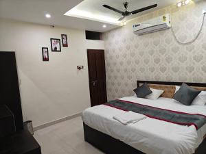 a bedroom with a large bed with a ceiling fan at Rapti Inn in Gorakhpur