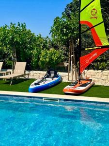 a sail boat and kayaks next to a swimming pool at Exclusive Resort Vista Hills Apartman Blue Horizon in Sevid +27 photos