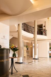 a lobby with a staircase and a vase of flowers at Phi Hotel Astoria in Susegana