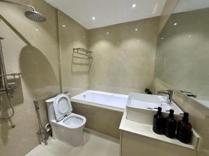 a bathroom with a toilet and a sink and a bath tub at Island Getaway Villa - 5BR with Patio in Male City +26 photos