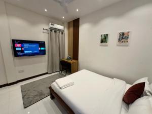 a bedroom with a bed and a flat screen tv at Island Getaway Villa - 5BR with Patio in Male City