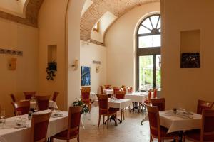 a restaurant with tables and chairs and a window at Phi Hotel Astoria in Susegana