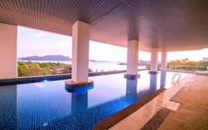 ein Swimmingpool mit Blick auf das Meer in der Unterkunft Adya Hotel Langkawi in Kuah