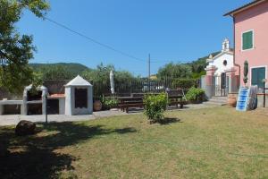 a yard with benches and a building and a fence at Elba Casale al Mare Cm2a in Marina di Campo