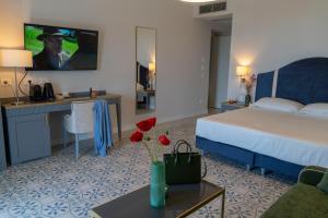 a hotel room with a bed and a desk at Villa Vincenza Deluxe Rooms in Capo dʼOrlando