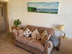 a teddy bear sitting on a couch in a living room at The Hutchinson Apartments in Douglas