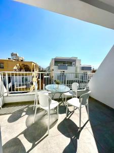 Un patio con sillas y una mesa en un balcón. en Serene Napa Suites - Heart of Ayia Napa, en Ayia Napa