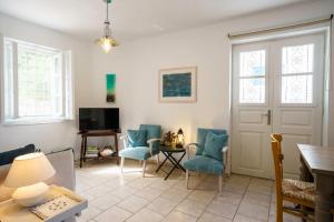 a living room with blue chairs and a table at Nostos in Hydra
