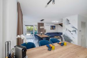 a living room with a table and blue chairs at Villa SUNSET I with private pool and beautiful sea view in Vrbnik
