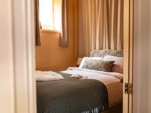 a small bedroom with a bed with a window at Chapman House 3 Bedroom Luxury Retreat in Norwich