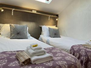 a hotel room with two beds with towels on them at The Hutchinson Apartments in Douglas