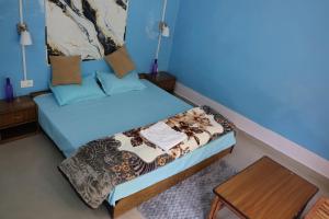 een kleine kamer met een bed en een tafel bij Tirthan Living Green Home Stays in Banjār +12 foto's