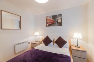 a bedroom with a bed and two lamps and a mirror at Bermondsey Central London Apartments in London