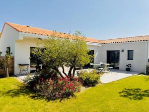 a house with a garden and a tree at Villa chic & Zen - Workation - Plage à 10min in Vaux-sur-Mer