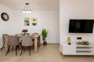 a dining room with a table and chairs and a tv at M&A Boutique House in Zakynthos
