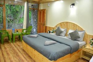 una camera da letto con un letto grande con testiera in legno di The Desire Manali a Manāli
