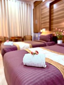 a hotel room with three beds with a towel on the bed at Rest Inn Hotel in Jāmb