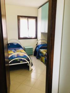 a bedroom with two beds and a window at Casa vacanze vista mare a Budoni - sam01 in Tanaunella