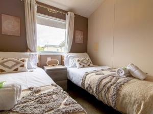 ウィットリー・ベイにあるPass the Keys Cozy 2-Bed Lodge by the Sea – Whitley Bay Retreatのベッド2台と窓のある寝室