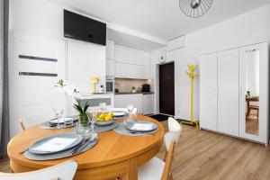 een keuken en eetkamer met een houten tafel en stoelen bij Piwna Apartament in Gdańsk